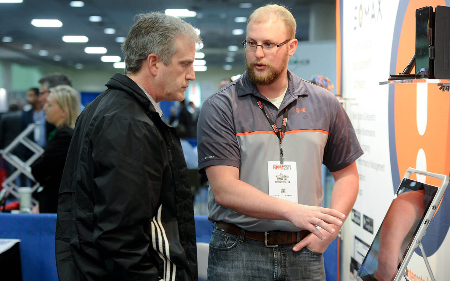 NFMT Exhibitor showing man a screen