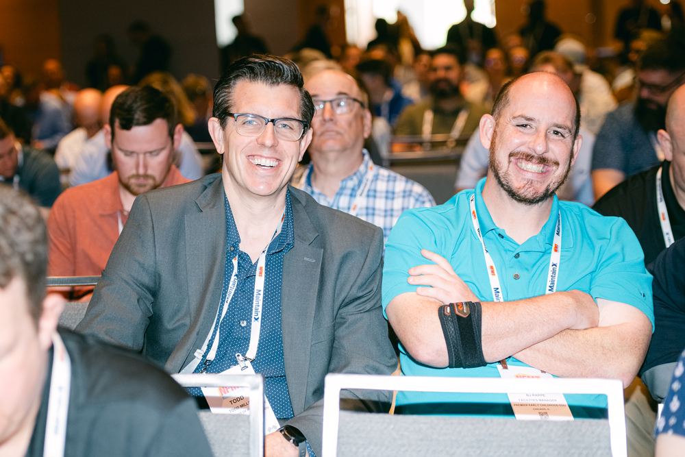 Two attendees share a laugh during a conference session